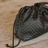 Close-up of the black woven leather Naomi Clutch with its leather drawstring